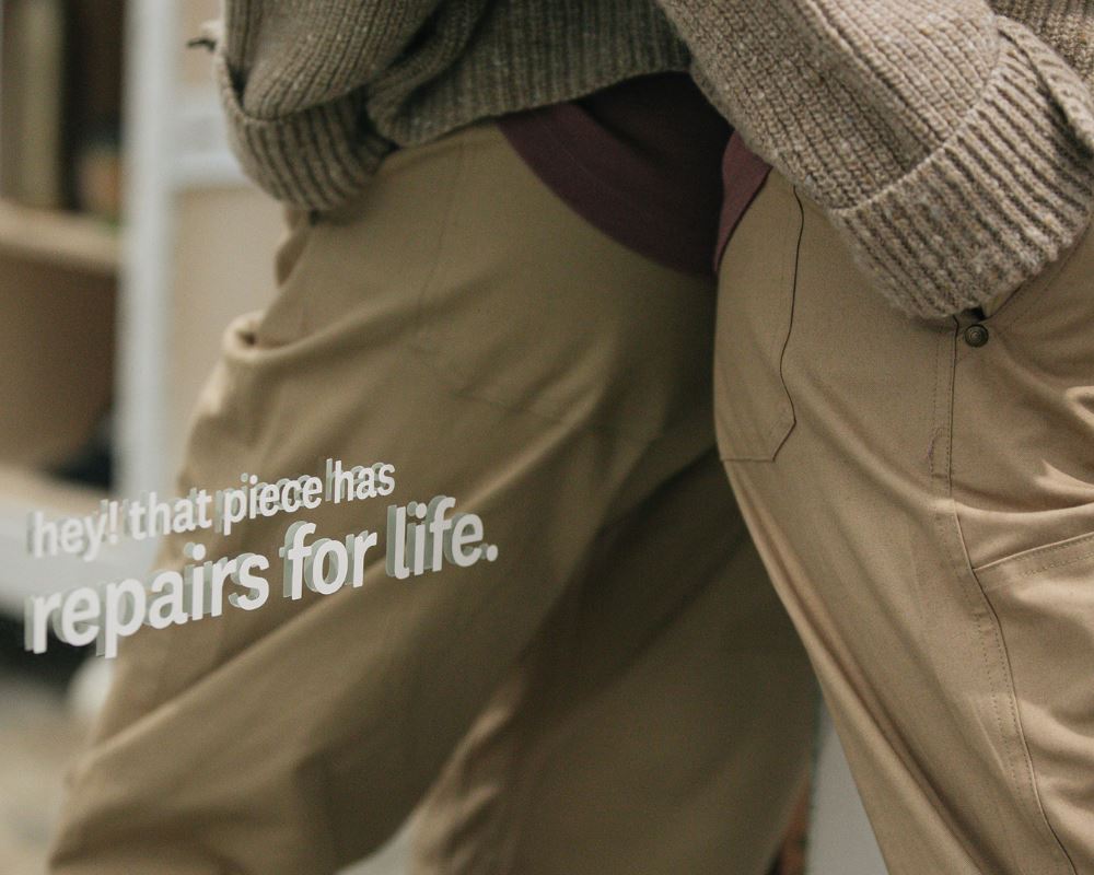 A woman leans against a mirror that says, "hey! that piece has repairs for life."