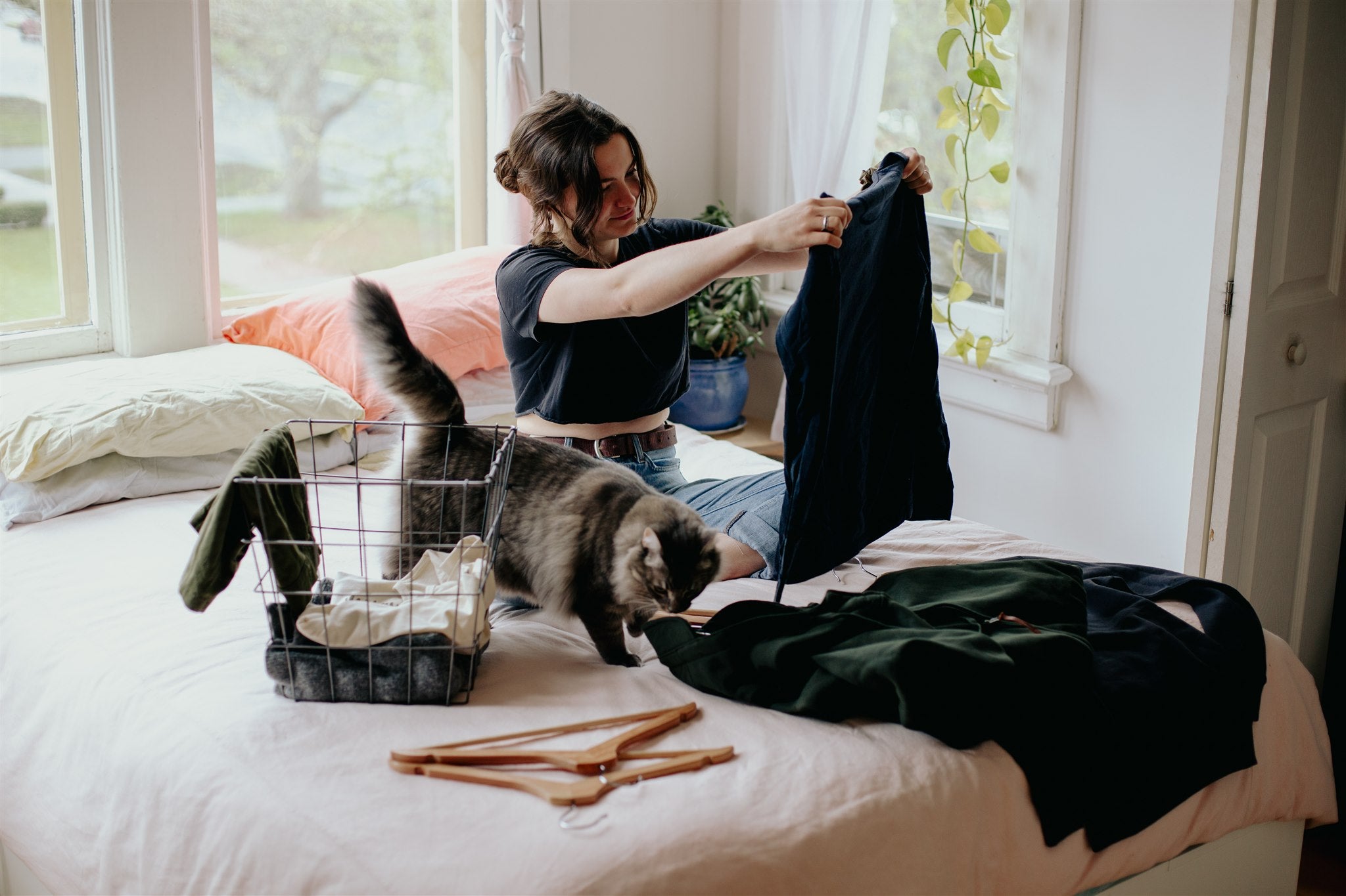 A woman and her cat sort through her closet to decide which items she will keep and which she will give away/sell second-hand on Second Life.