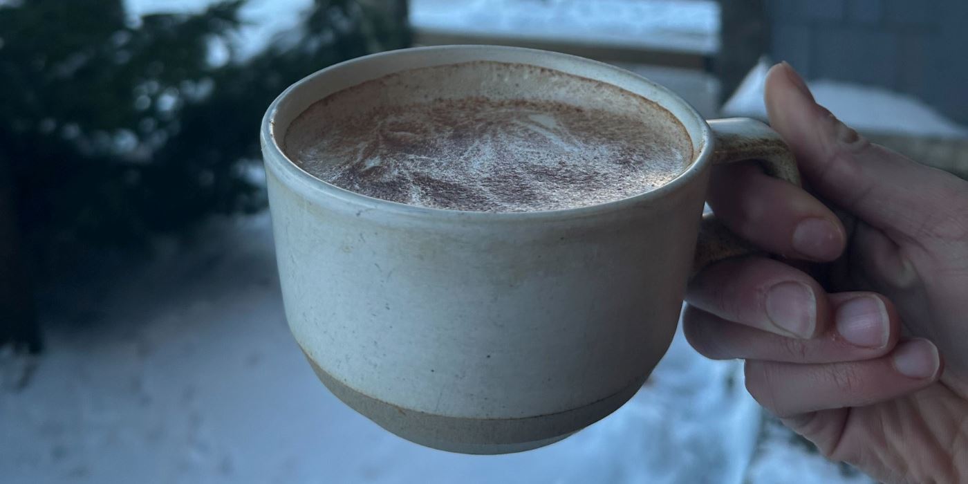 Someone holding Whistler Cafe's housemade chai made into a latte